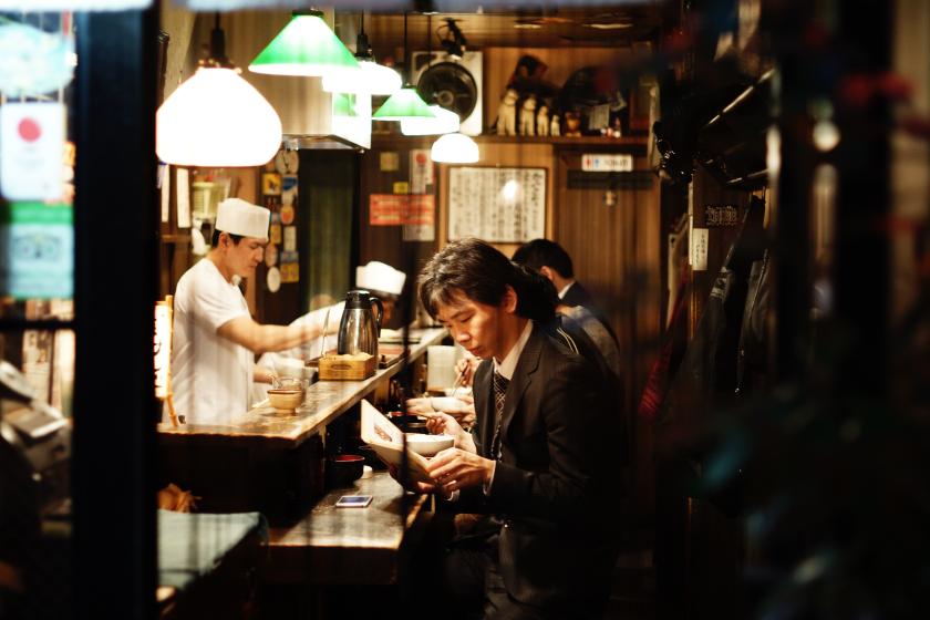 Nishida had er genoeg van om alleen te eten, nu wachten zijn 'vrouw' en 'dochter' op hem met een lekkere maaltijd als hij 's avonds uit zijn werk komt. Japanse mannen in een eethuis
