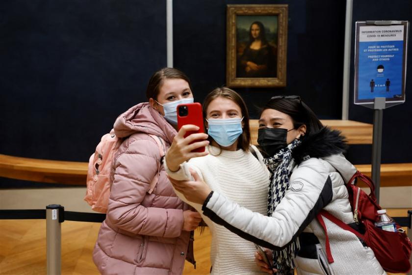 Drie jonge meiden maken selfies met de Mona Lisa Drie jonge meiden voor de Mona Lisa