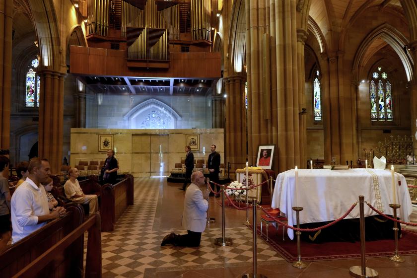People attend a prayer vigil for Australian Catholic cardinal George Pell as he lies in state at St Mary's Cathedral in Sydney on February 1, 2023. Pell died in Rome in January aged 81. Once considered the third most influential man in the Vatican, Pell's final years were marked by allegations of sexual abuse and criticism of his hard-line positions on abortion and gay marriage. Rick Rycroft / POOL / AFP