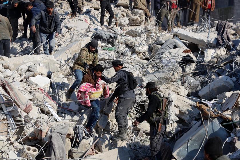 A man carries the body a child pulled out from the rubble in the town of Harim, in Syria's rebel-held noryhwestern Idlib province on the border with Turkey, on February 8, 2023, two days after a deadly earthquake that hit Turkey and Syria. The death toll from the massive earthquake that struck Turkey and Syria on February 6 rose above 8,300, official data showed, with rescue workers on February 8 still searching for trapped survivors. Mohammed AL-RIFAI / AFP