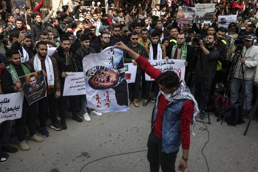 A university student sents a poster of Israel's Minister of National Security Itamar Ben Gvir, during a demonstration in Gaza City on February 26, 2023, in support of the West Bank and against the Aqaba summit between Israel and Palestinians. MAHMUD HAMS / AFP