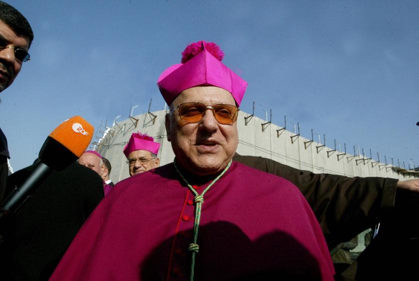 Passing through the controversial separation barrier being built by Israel (behind) the Latin Patriarch of Jerusalem Michel Sabbah speaks to the press upon his arrival at the main entrance of the West Bank biblical town of Bethlehem to attend Christmas celebrations at the Church of the Nativity, where Christians believe Jesus Christ was born, 24 December 2006. The celebrations have been overshadowed by a long-dormant Israeli-Palestinian peace process and recent Palestinian in-fighting in Gaza and the West Bank. AFP PHOTOS/MUSA AL-SHAER Passing through the controversial separation barrier being built by Israel (behind) the Latin Patriarch of Jerusalem Michel Sabbah speaks to the press upon his arrival at the main entrance of the West Bank biblical town of Bethlehem to attend Christmas celebrations at the Church of the Nativity, where Christians believe Jesus Christ was born, 24 December 2006. The celebrations have been overshadowed by a long-dormant Israeli-Palestinian peace process and recent Palestinian in-fighting in Gaza and the West B