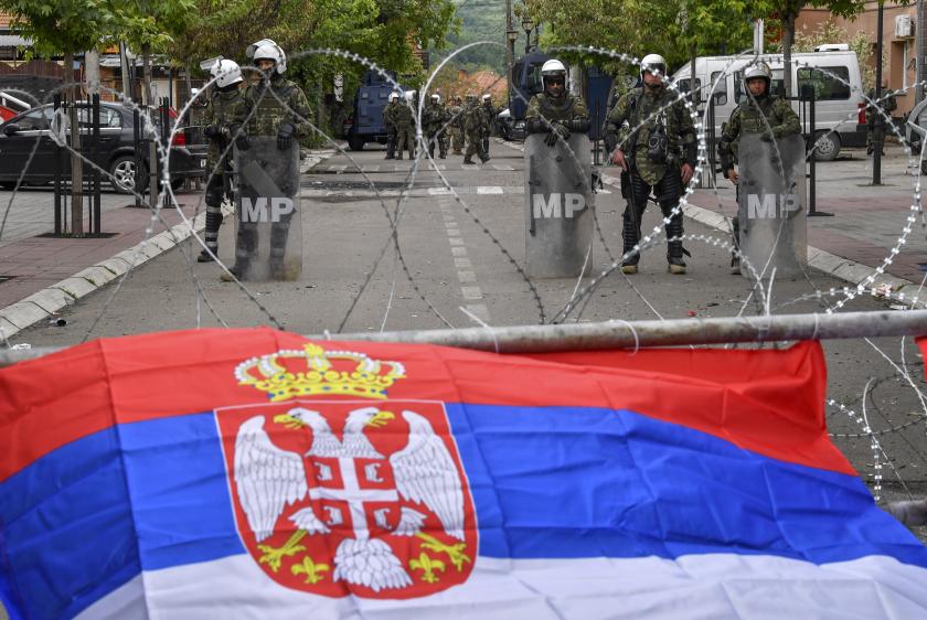 The Serbian flag is flying attached to the fence next to the soldiers of the NATO-led international peacekeeping Kosovo Force (KFOR) who stand guard in front of the building of the municipality in Zvecan, Kosovo, 31 May 2023. At least 30 KFOR peacekeepers and 52 civilians were injured after clashes between security forces and ethnic Serbs broke out in Zvecan on 30 May 2023. Tensions continue in northern Kosovo’s region, with a majority of ethnic Serbian people, which arose after ethnic Albanians mayors took offices in four towns following elections boycotted by the Serbian community. EPA/GEORGI LICOVSKI The Serbian flag is flying attached to the fence next to the soldiers of the NATO-led international peacekeeping Kosovo Force (KFOR) who stand guard in front of the building of the municipality in Zvecan, Kosovo, 31 May 2023. At least 30 KFOR peacekeepers and 52 civilians were injured after clashes between security forces and ethnic Serbs broke out in Zvecan on 30 May 2023. Tensions continue in northern Kosovo’s region, with a majority of ethnic Serbian people, which arose after ethnic Albanians mayors took