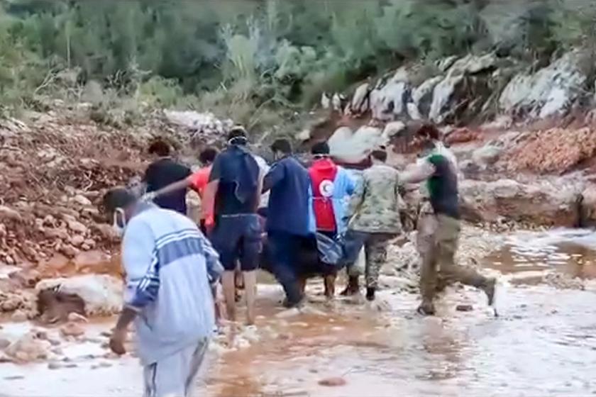 This image grab from handout video released by the Libyan Red Crescent on September 13, 2023 shows volunteers carrying a body bag during search operations after deadly floods in the east of the country. Libya on September 13 was counting its dead with 2,300 people confirmed killed when enormous flash floods unleashed by Storm Daniel hit the eastern city of Derna, where the Red Cross warned that 10,000 are missing. Disaster relief missions gathered pace with Turkey, Egypt and the UAE among the first countries to send aid, as the UN announced $10 million in support for survivors, including 30,000 people left homeless. The Libyan Red Crescent / AFP This image grab from handout video released by the Libyan Red Crescent on September 13, 2023 shows volunteers carrying a body bag during search operations after deadly floods in the east of the country. Libya on September 13 was counting its dead with 2,300 people confirmed killed when enormous flash floods unleashed by Storm Daniel hit the eastern city of Derna, where the Red Cross warned that 10,000 are missing. Disaster relief missions gathered pace with Turkey, Egypt and the UAE among the first countrie