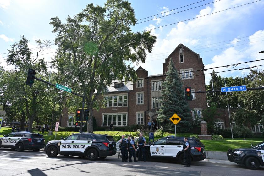 Police and first responders work at the scene of a shooting near Annunciation Church and Catholic School in Minneapolis, Minneosta, on August 27, 2025. Two children were shot dead when a gunman attacked a Minneapolis church on Wednesday, with 17 people injured, 14 of them children, police said. The gunman "began firing a rifle through the church windows towards the children sitting in the pews at the mass," Minneapolis police chief Brian O'Hara told reporters. The pupils were marking the first week of the s