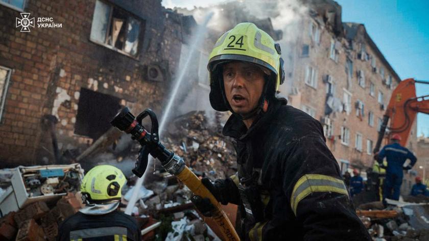 This handout photograph taken and released by the State Emergency Service of Ukraine on August 28, 2025, shows firefighters putting out a fire on a residential building heavily damaged during a large-scale Russian drone and missile attack on Kyiv, amid the Russian invasion of Ukraine.