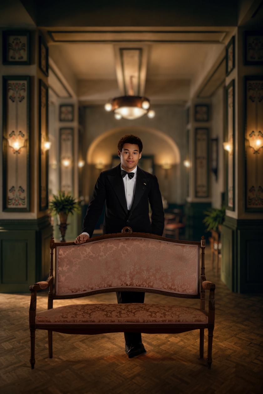 Een man in pak poseert in een luxe hotel