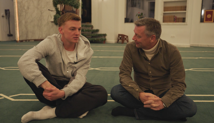 Jongen in grijs vest en man in groene blouse in moskee