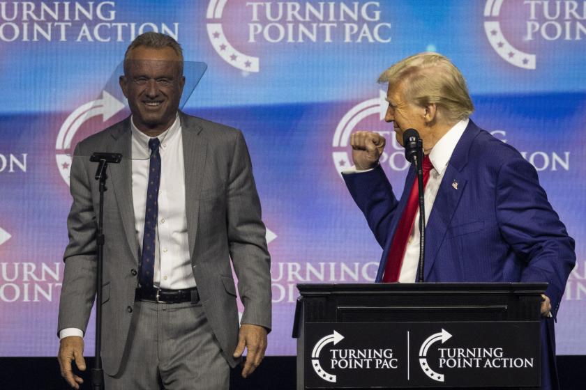 Former US President and Republican presidential candidate Donald Trump (R) raises a fist as he brings Robert F. Kennedy Jr. onto the stage during a campaign rally at the Gas South Arena in Duluth, Georgia, on October 23, 2024. Former US President and Republican presidential candidate Donald Trump (R) raises a fist as he brings Robert F. Kennedy Jr. onto the stage during a campaign rally at the Gas South Arena in Duluth, Georgia, on October 23, 2024.