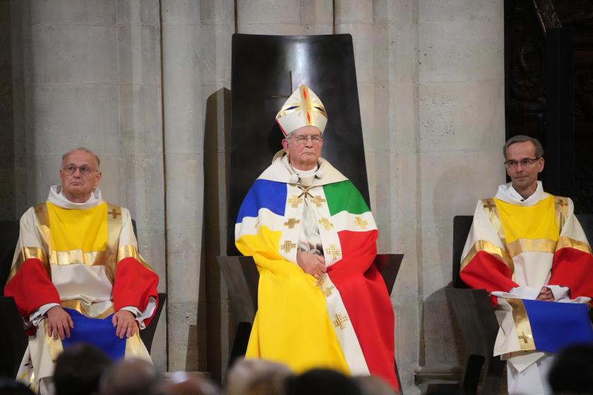 Aartsbisschop Ulrich zit, geflankeerd door twee diakens, op zijn cathedra in de kathedraal van Parijs tijdens de heropeningsplechtigheid op zaterdagavond 7 december 2024. Aartsbisschop Ulrich zit, geflankeerd door twee diakens, op zijn cathedra in de kathedraal van Parijs tijdens de heropeningsplechtigheid op zaterdagavond 7 december 2024.