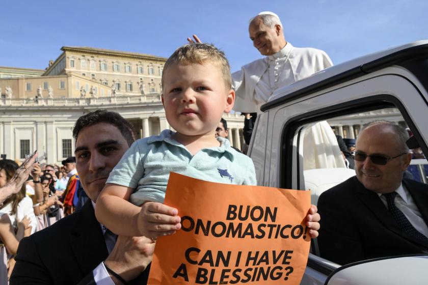 A handout picture provided by the Vatican Media shows a child holding a sign as Pope Leo XIV (C-R) greets the faithful during the weekly general audience in Saint Peter's Square, Vatican City, 17 September 2025.