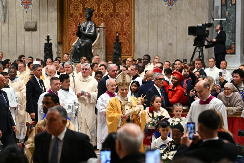 Pope Leo XIV (C) carries the statue of the Baby Jesus at the end of the Christmas Eve mass at St Peter's Basilica in the Vatican on December 24, 2025. Andreas SOLARO / AFP