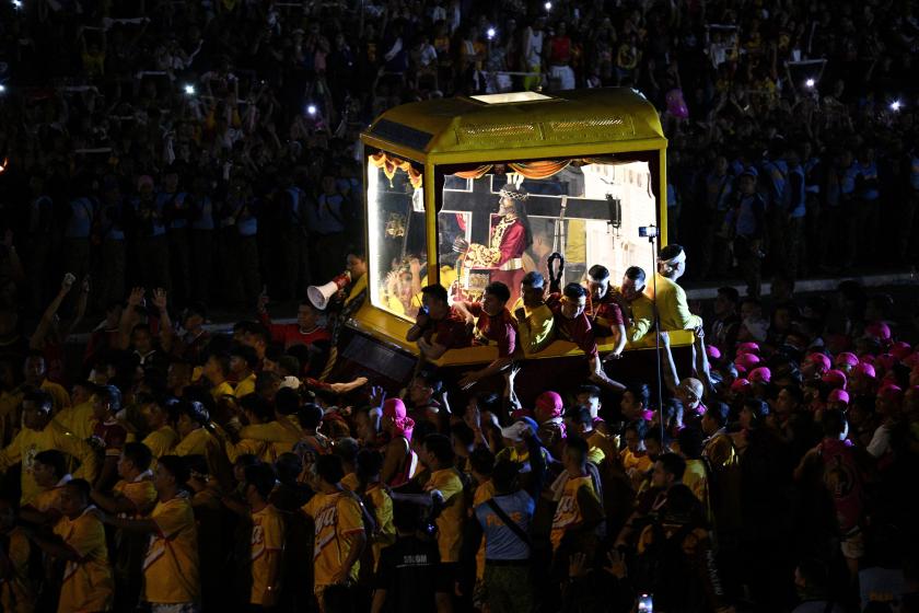 Philippine Catholic devotees join along with the carriage carrying the image of Jesus Nazareno, also known as Jesus the Nazarene, during the annual religious procession in Manila on January 9, 2026.  TED ALJIBE / AFP