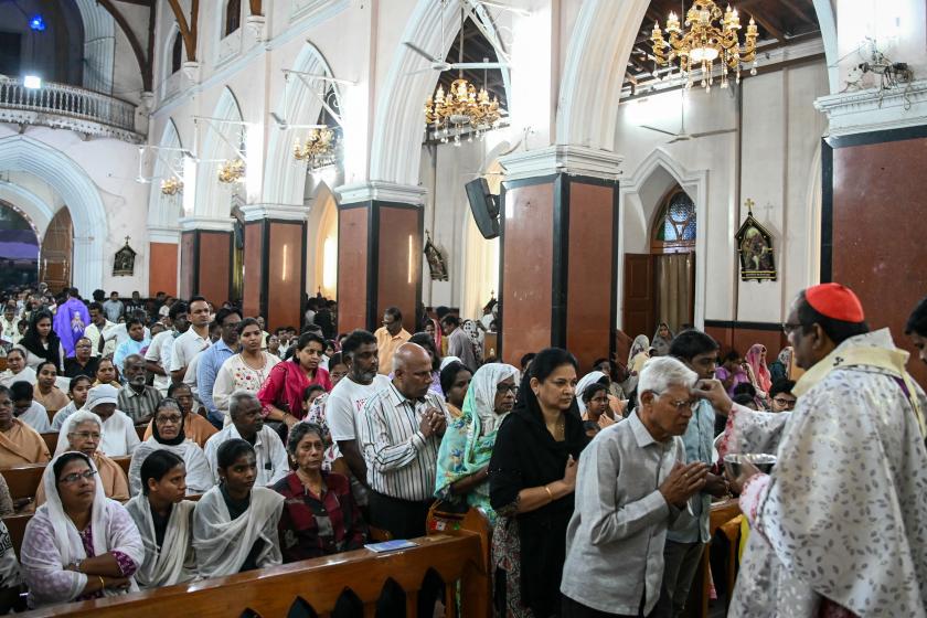 An archbishop applies ash to the forehead of devotees during Ash Wednesday mass service at Saint Mary’s Basilica in Secunderabad on February 18, 2026. Noah SEELAM / AFP