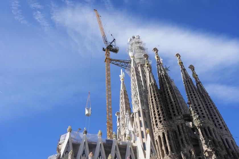 Een kraan tilt een deel van de bovenarm van het kruis van de Jezus-toren op de Sagrada Familia in Barcelona op 20 februari 2026. EPA/ENRIC FONTCUBERTA