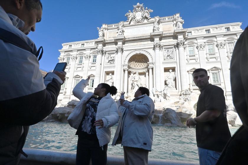Visitors throw coins into the Trevi Fountain in Rome after the city introduces a two-euro paid entry, on February 2, 2026. A new ticketing system goes into effect for the first time at the Trevi Fountain, one of Rome's most famous monuments and the latest tourist attraction to require admission in an effort to control crowds. The City of Rome is starting to charge tourists and non-residents a fee for close-up access to the Trevi Fountain. Andreas SOLARO / AFP