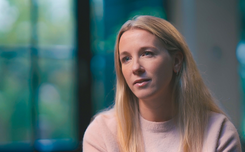 een vrouw met een lichtroze trui aan