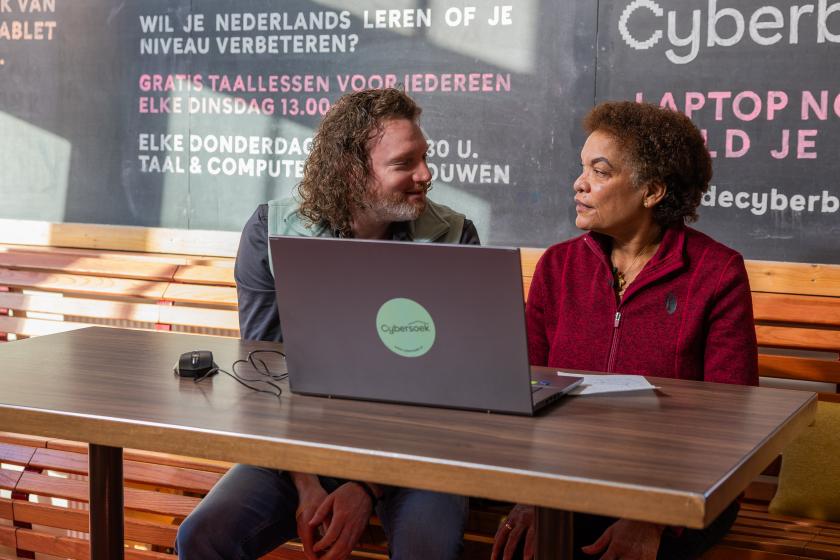 Man en vrouw zitten naast elkaar en zitten achter een laptop