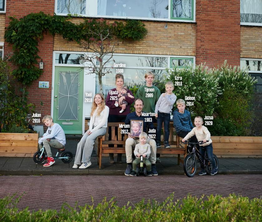 Gezin voor het huis met namen erbij