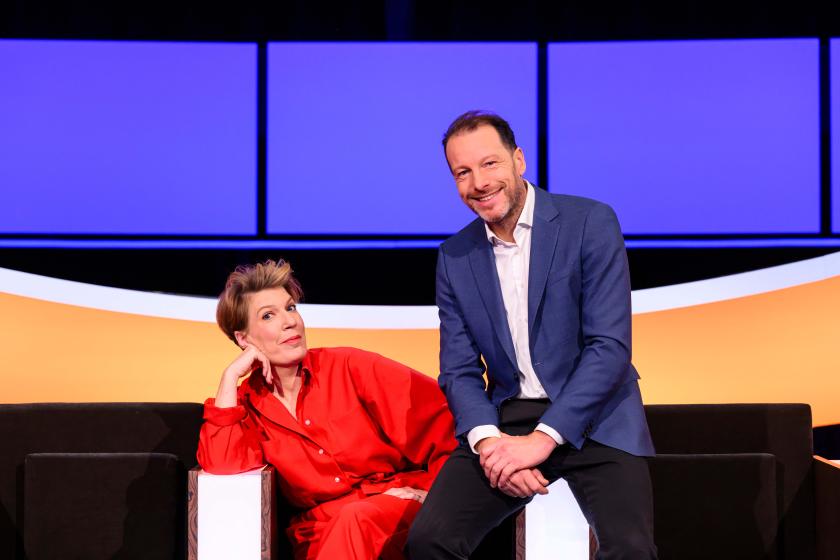 Man in blauw pak en vrouw in rood pak in studio