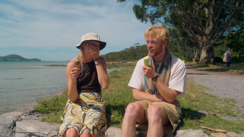Man en vrouw op grasveld lachend met eten