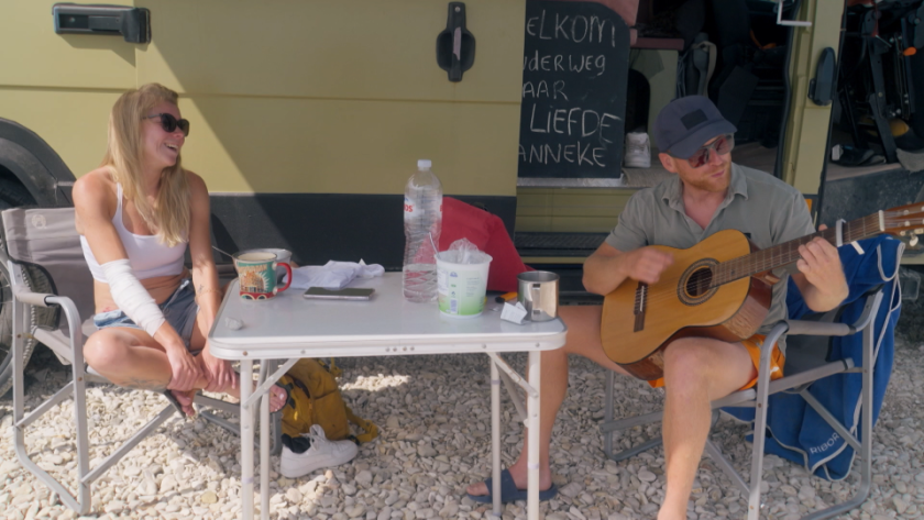 Man en vrouw aan tafel bij camper