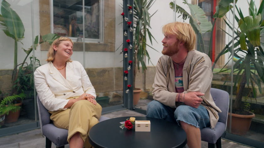 Man en vrouw buiten aan tafel pratend