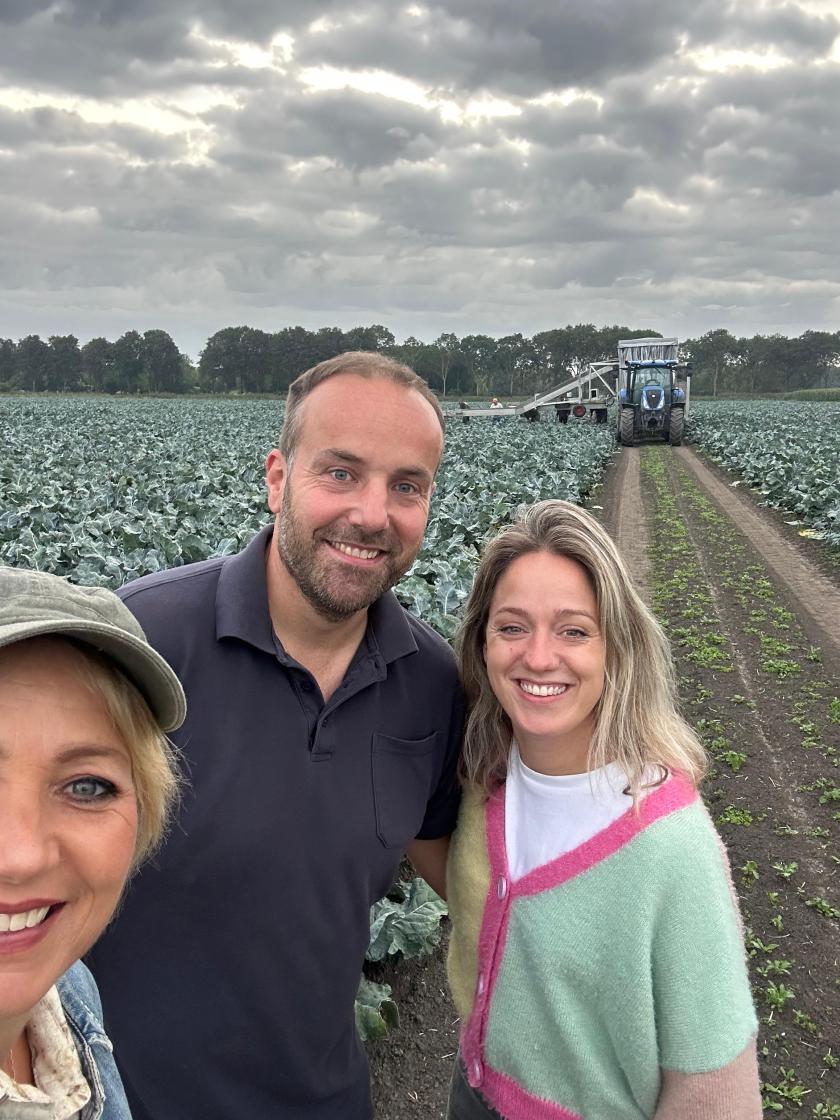 Een selfie van drie personen in een broccoliveld