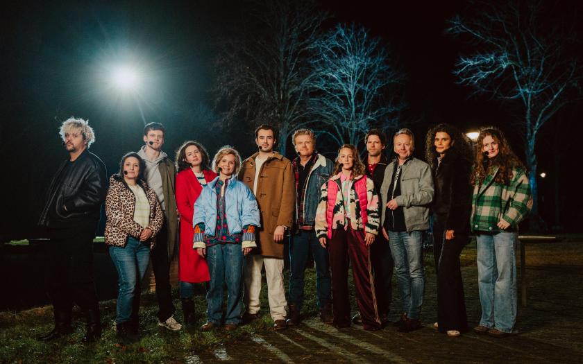 Groep acteurs geposeerd in het donker