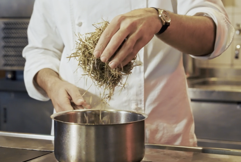 Hand die hooi in pan doet