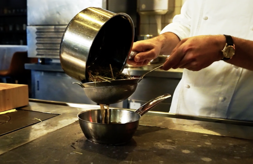 Man die hooi uit pan zeeft