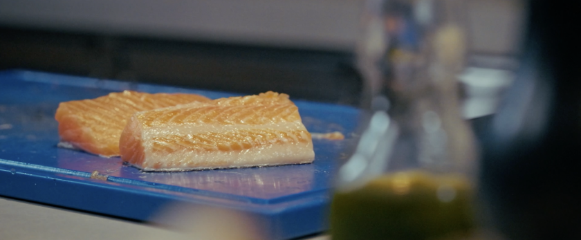 Een stuk rauwe vis op een blauw bord