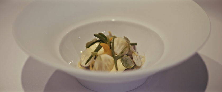 Bord met culinair gerecht met kokkels en lam