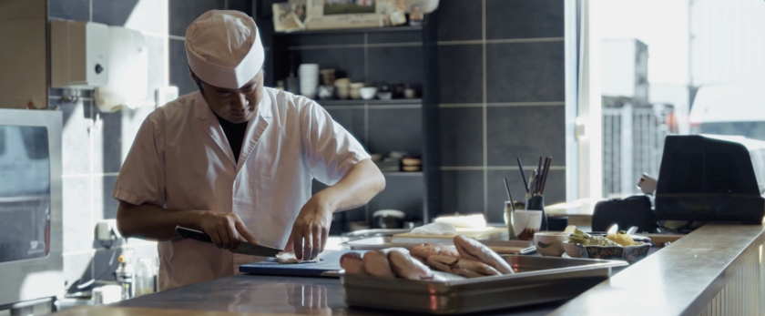 Kok met koksmuts in keuken vis bereiden