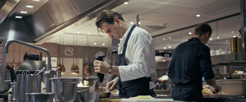 Man met schort in keuken aan het mixen