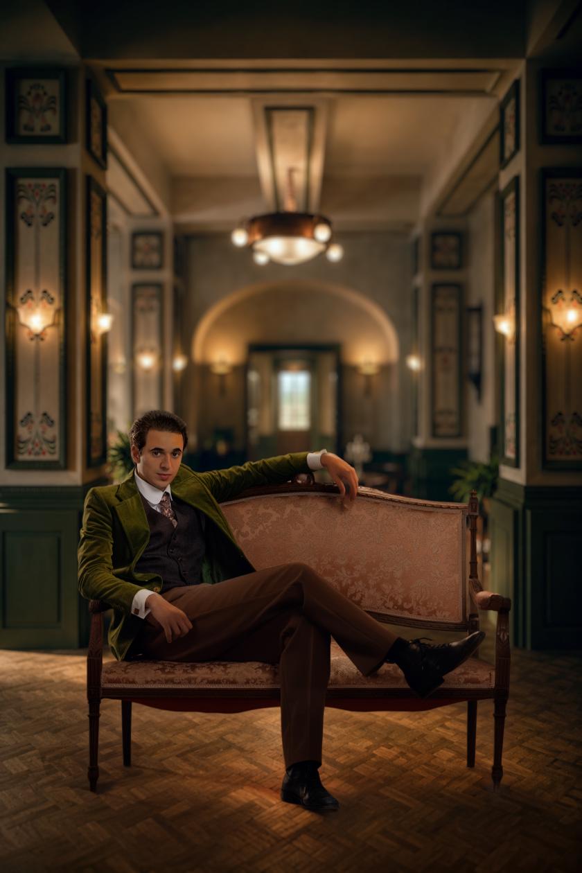 Een man zit op een bank in een luxe hotel
