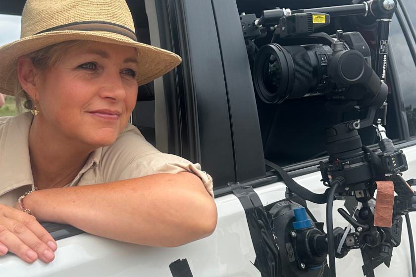 Een vrouw zit in een auto met een camera