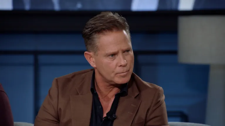 Man in bruin pak in studio kijkend naar rechts