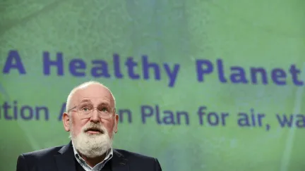frans timmermans voor een groen scherm