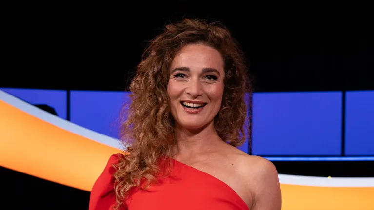 Lachende vrouw in rode jurk met schaal