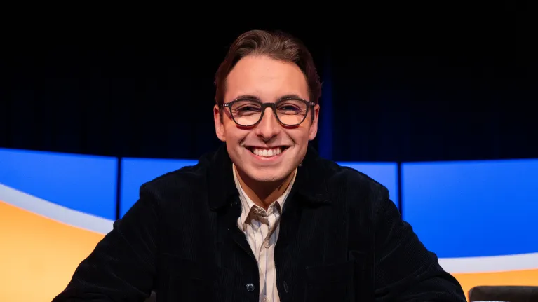 Jongen met bril en zwart vest in de studio