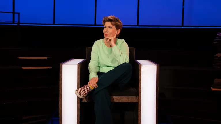 Vrouw zit in een stoel met haar hand onder haar hoofd