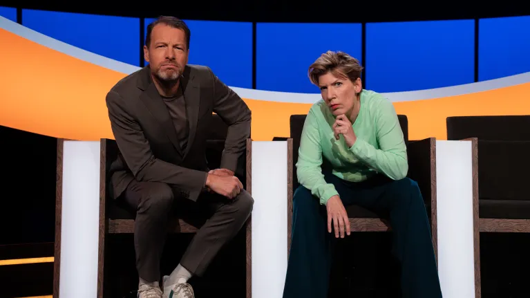 Man en vrouw in studio kijken serieus