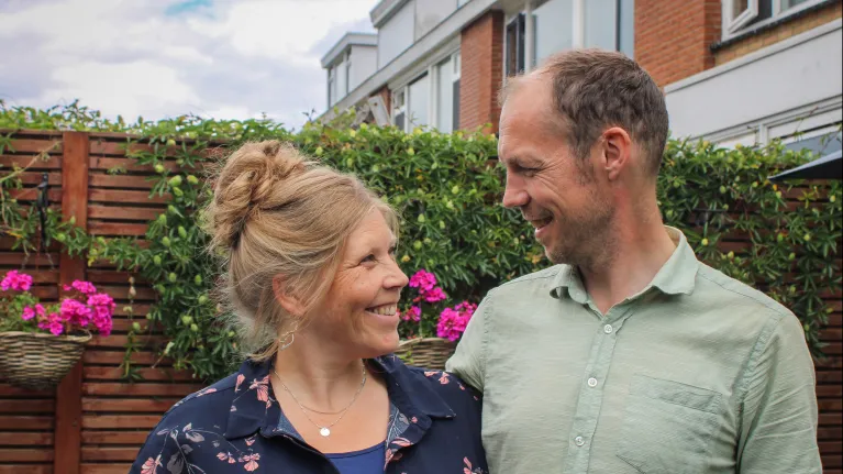 Een man en een vrouw kijken elkaar lachend aan