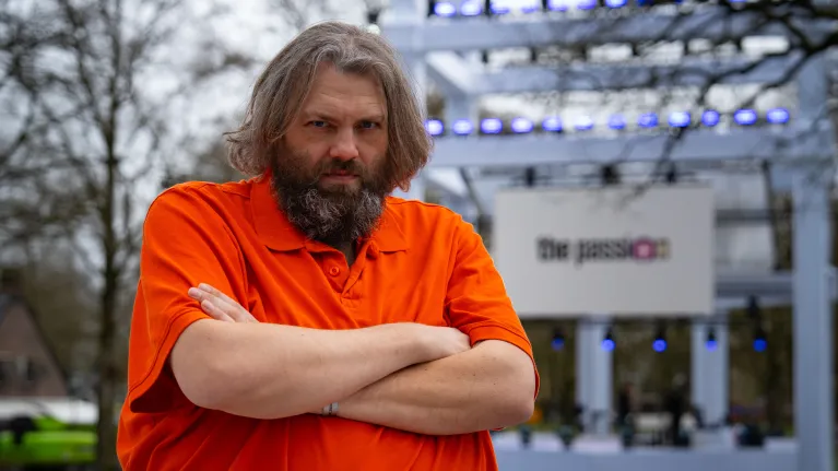 Man in oranje pak kijkt serieus