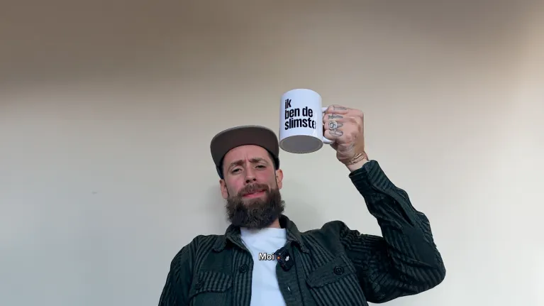 een man houdt een mok in de lucht