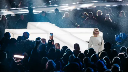 Zangeres Marlijn Weerdenburg voor het witverlichte kruis van The Passion