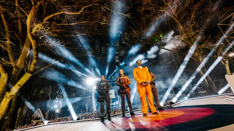 Man in oranje pak met politieagenten