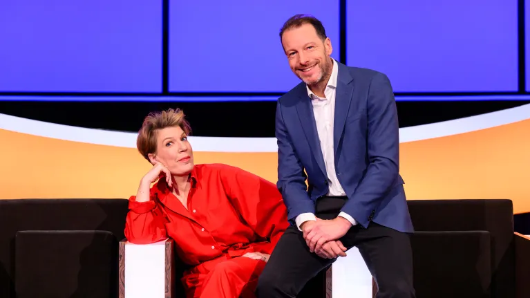 Man in blauw pak en vrouw in rood pak in studio