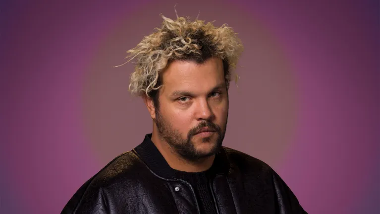 Man in zwarte jas kijkt serieus